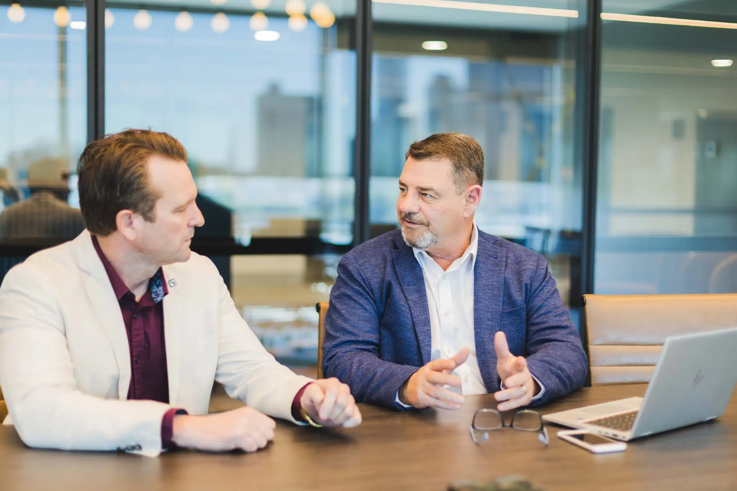 Two QIB Group professionals in discussion at a boardroom table