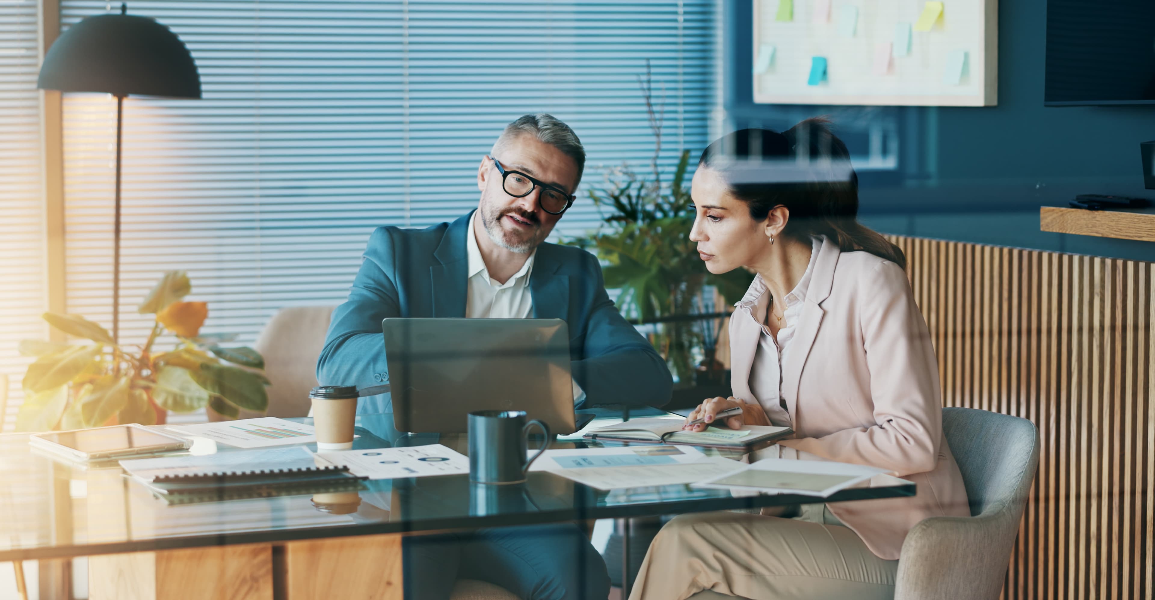 Two business professionals reviewing insurance documents together at a desk