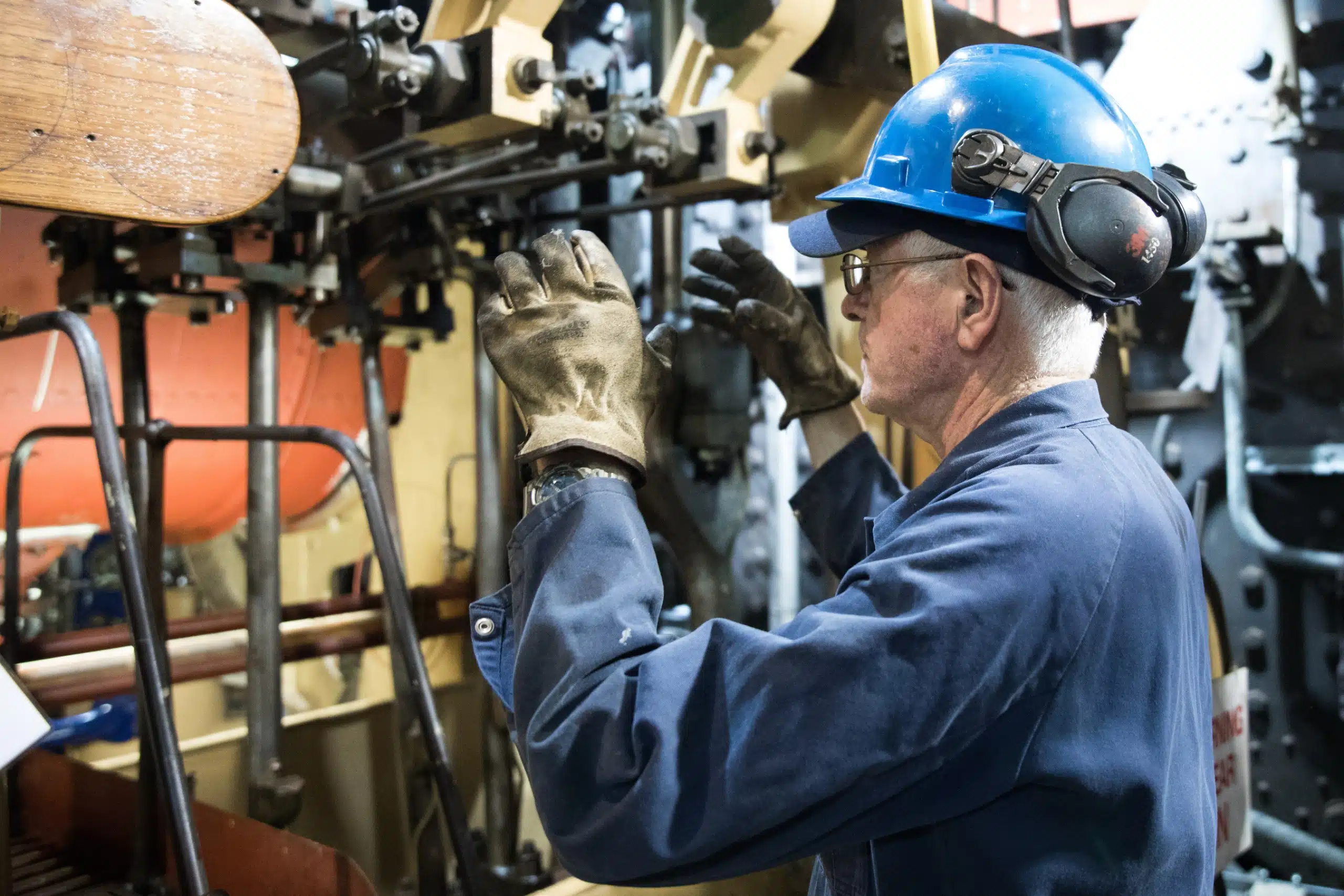 Marine engineer working on machinery in a ship's engine room