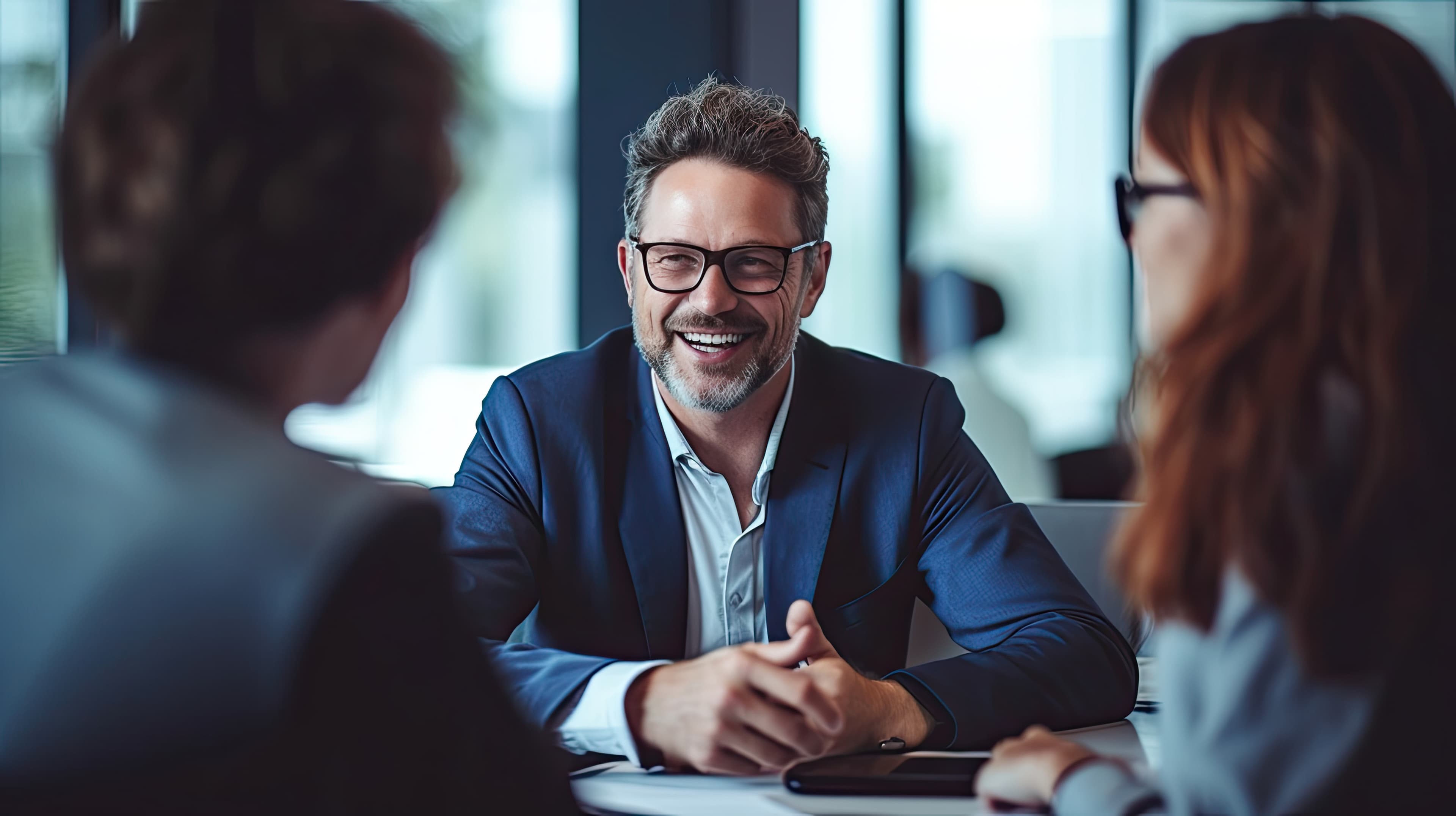 Insurance broker smiling while meeting with clients in an office