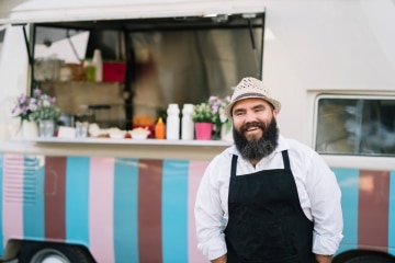 Man smiling in front of food truck