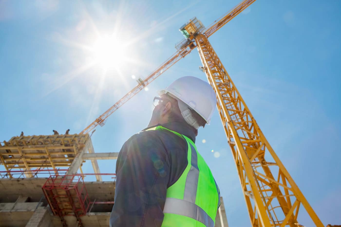 Construction worker looking up at sun