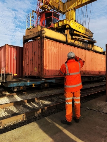 Rail worker loading shipping containers