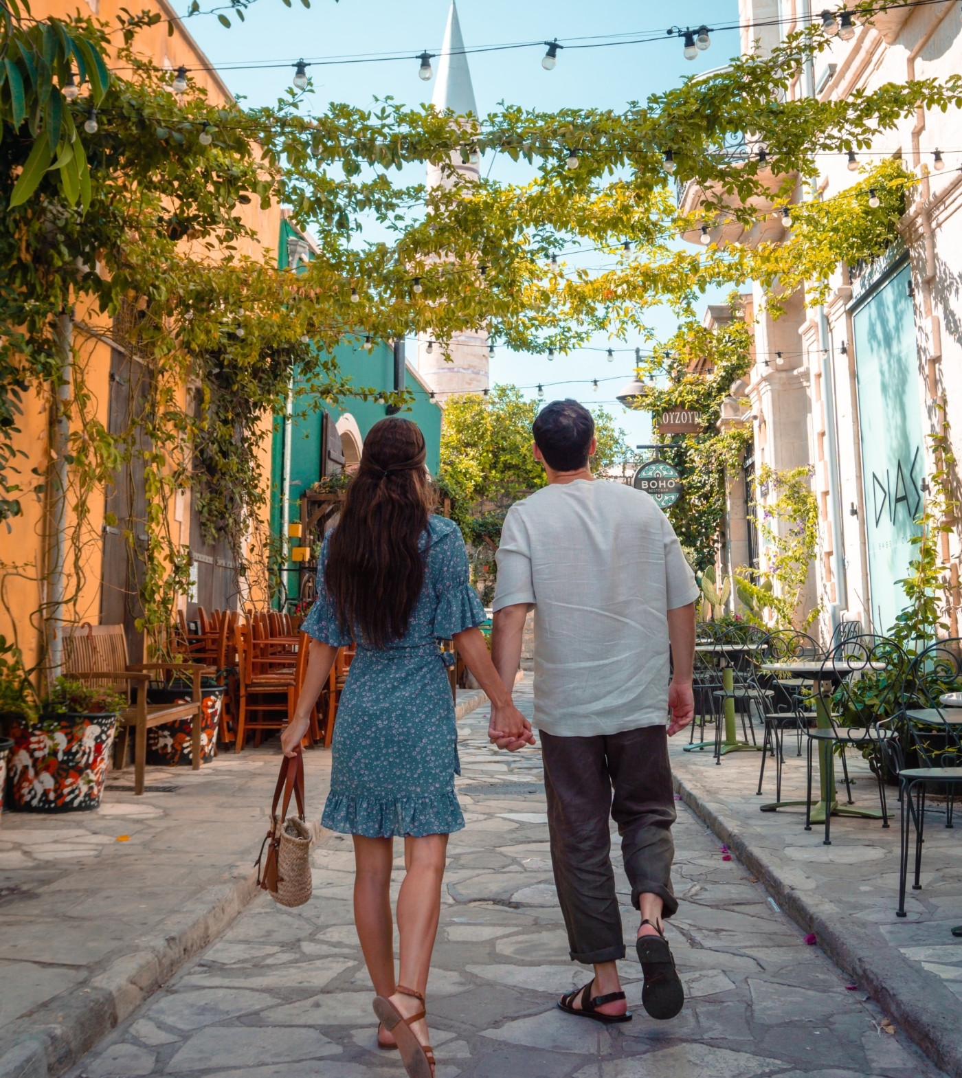 couple holding hands walking sun dappled streets on their travels